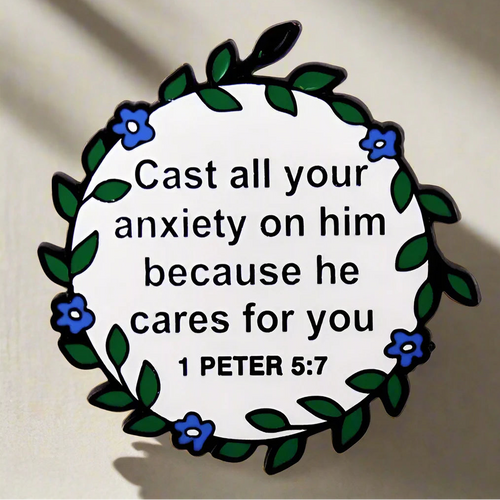 SĒK Apparel 1 Peter 5:7 enamel pin — floral Christian lapel pin with 'Cast all your anxiety on Him' scripture, front view on white background
