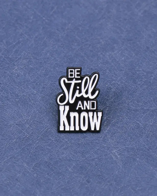 SĒK Apparel Be Still and Know enamel pin — faith-inspired Christian lapel pin with 'Be Still and Know' text referencing Psalm 46:10, front view 