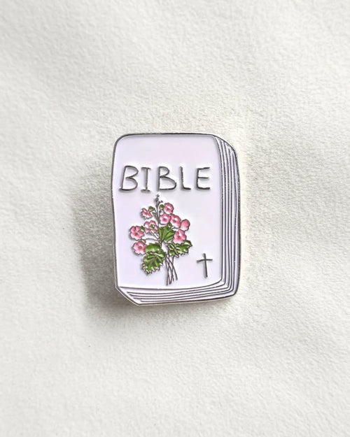 SĒK Apparel Bible enamel pin — brooch shaped like a Bible with floral design and cross detail, faith-inspired Christian lapel pin