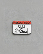 A pin with a name tag that reads 'Hello! I'm a Child of God'.