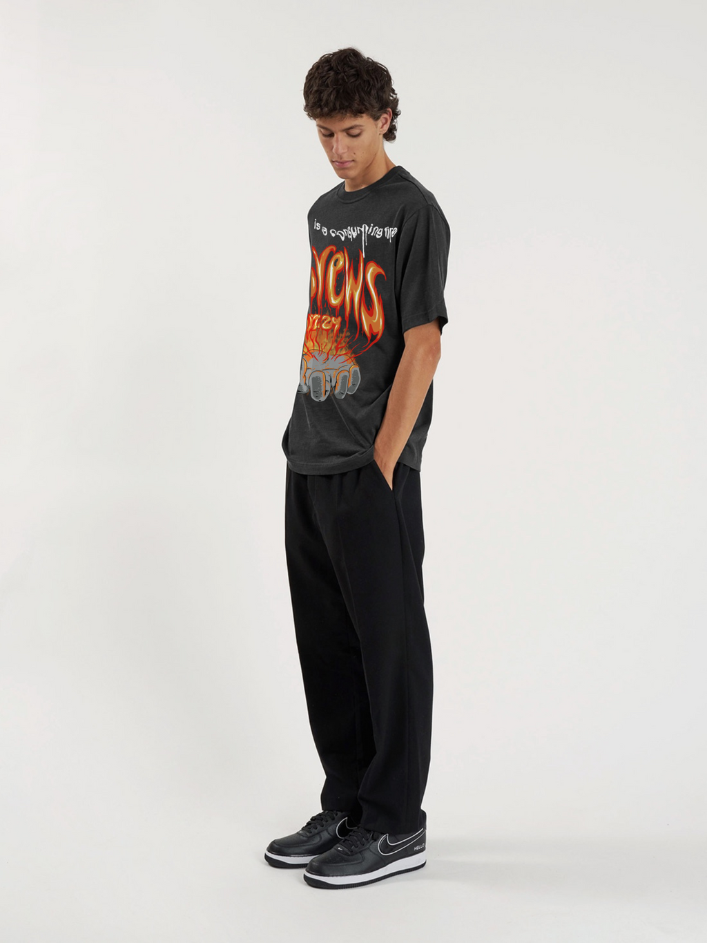 Man wearing the SĒK Apparel Hebrews 12:29 Vintage Tee — lifestyle shot of faith-inspired 'Consuming Fire' Christian graphic tee, vintage washed style
