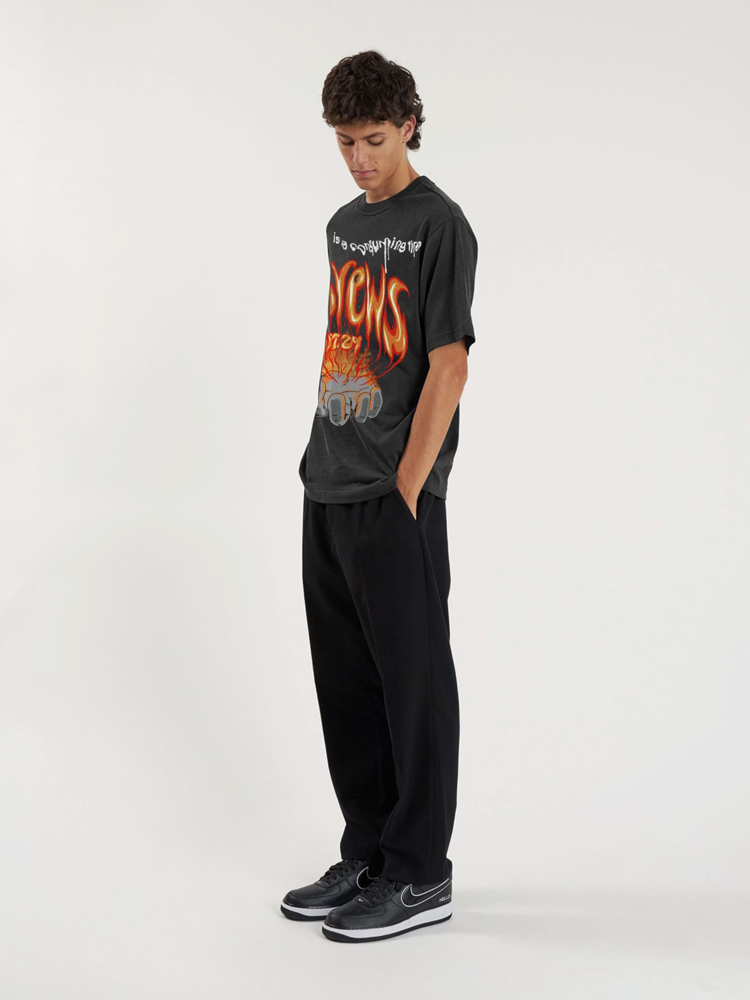 Man wearing the SĒK Apparel Hebrews 12:29 Vintage Tee — lifestyle shot of faith-inspired 'Consuming Fire' Christian graphic tee, vintage washed style