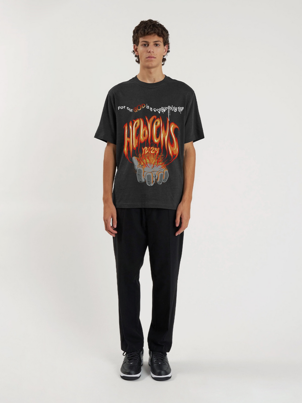 Man wearing the SĒK Apparel Hebrews 12:29 Vintage Tee — front view of 'Consuming Fire' Christian graphic tee with vintage distressed print