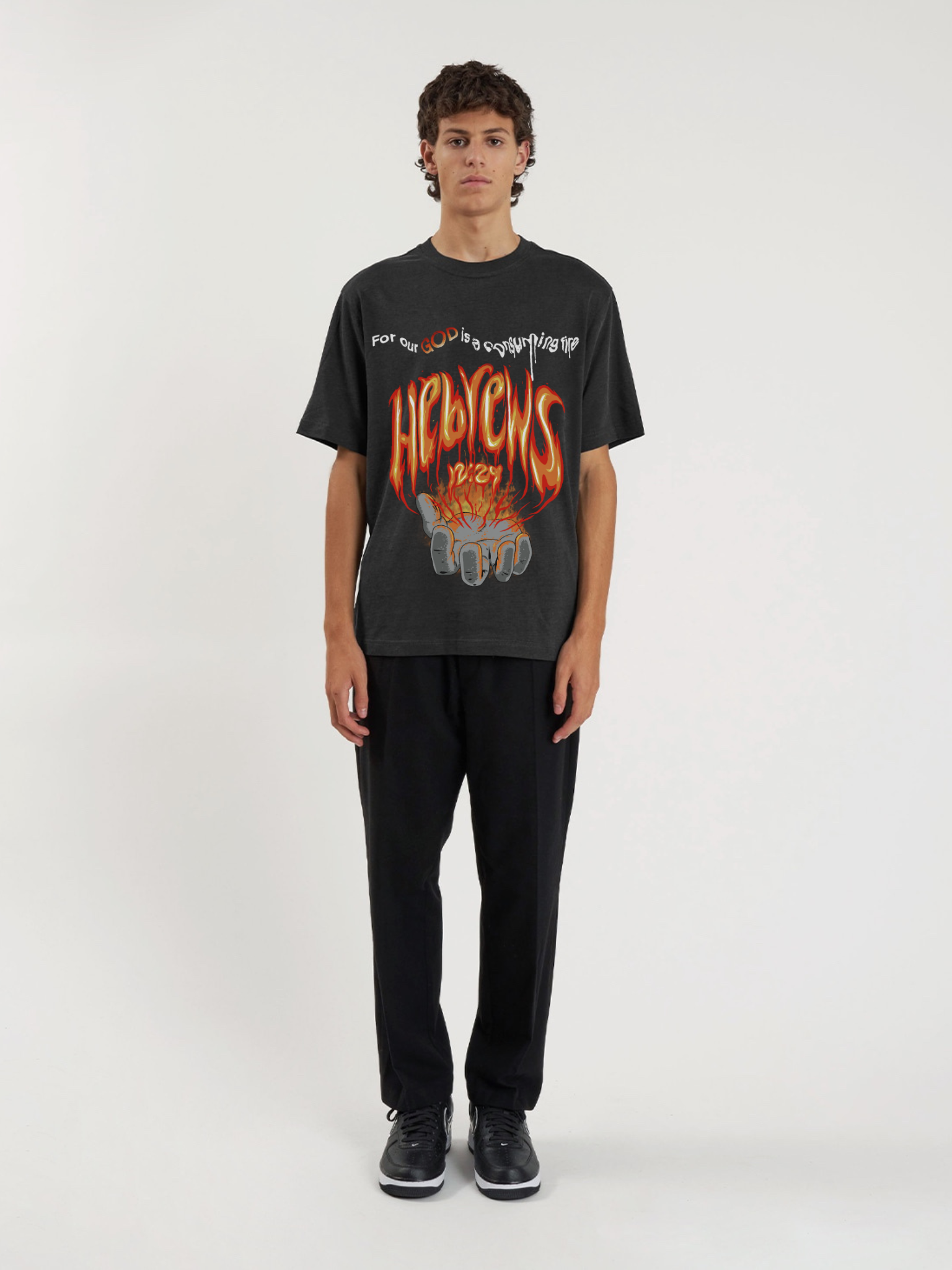 Man wearing the SĒK Apparel Hebrews 12:29 Vintage Tee — front view of 'Consuming Fire' Christian graphic tee with vintage distressed print