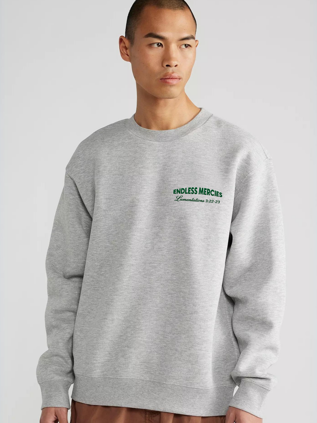 Man wearing the SĒK Apparel Endless Mercies Crewneck in heather gray — front view of premium faith-inspired Christian sweatshirt with embroidered 'Endless Mercies' detail, referencing Lamentations 3:22-23