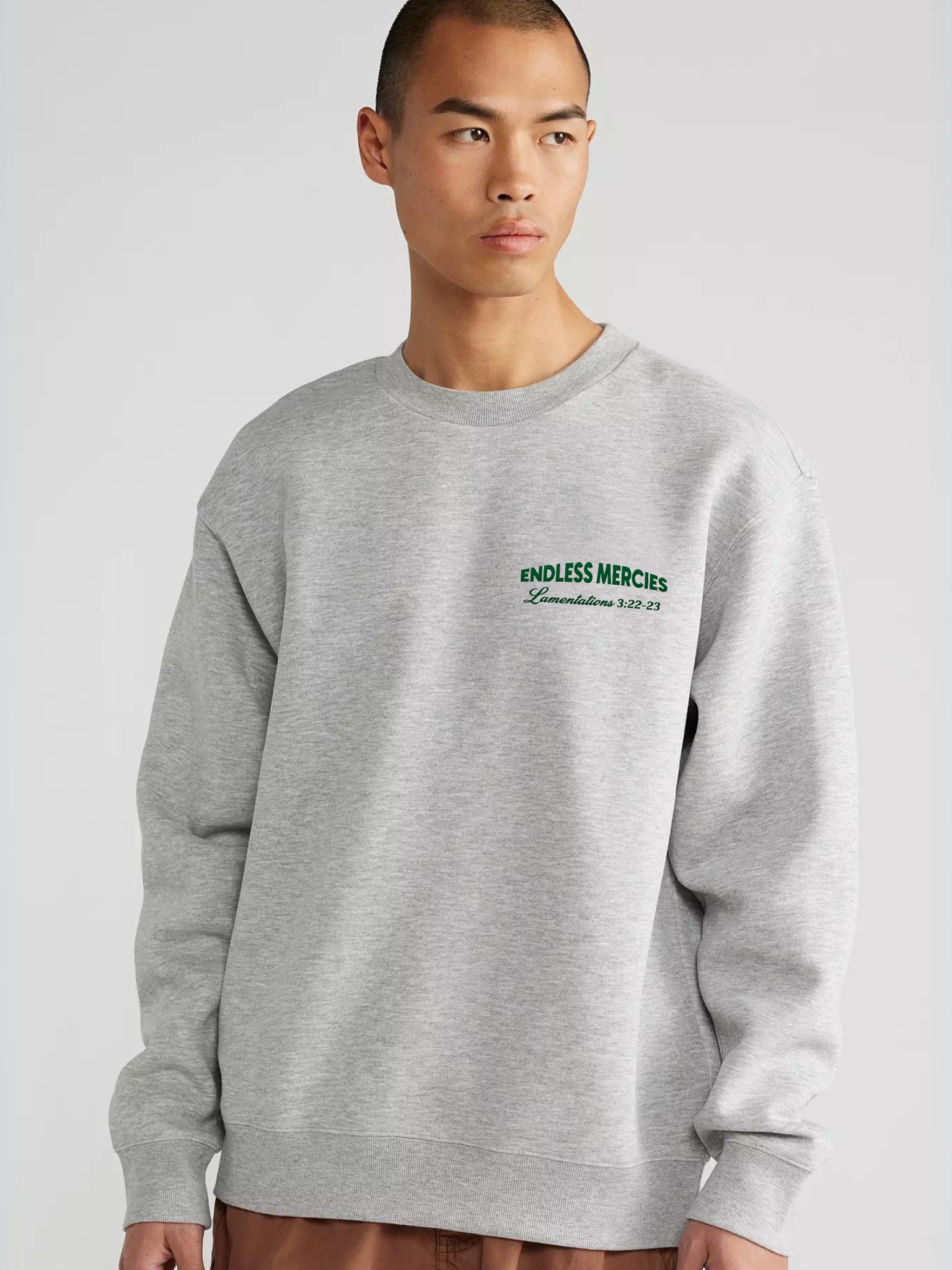 Man wearing the SĒK Apparel Endless Mercies Crewneck in heather gray — front view of premium faith-inspired Christian sweatshirt with embroidered 'Endless Mercies' detail, referencing Lamentations 3:22-23