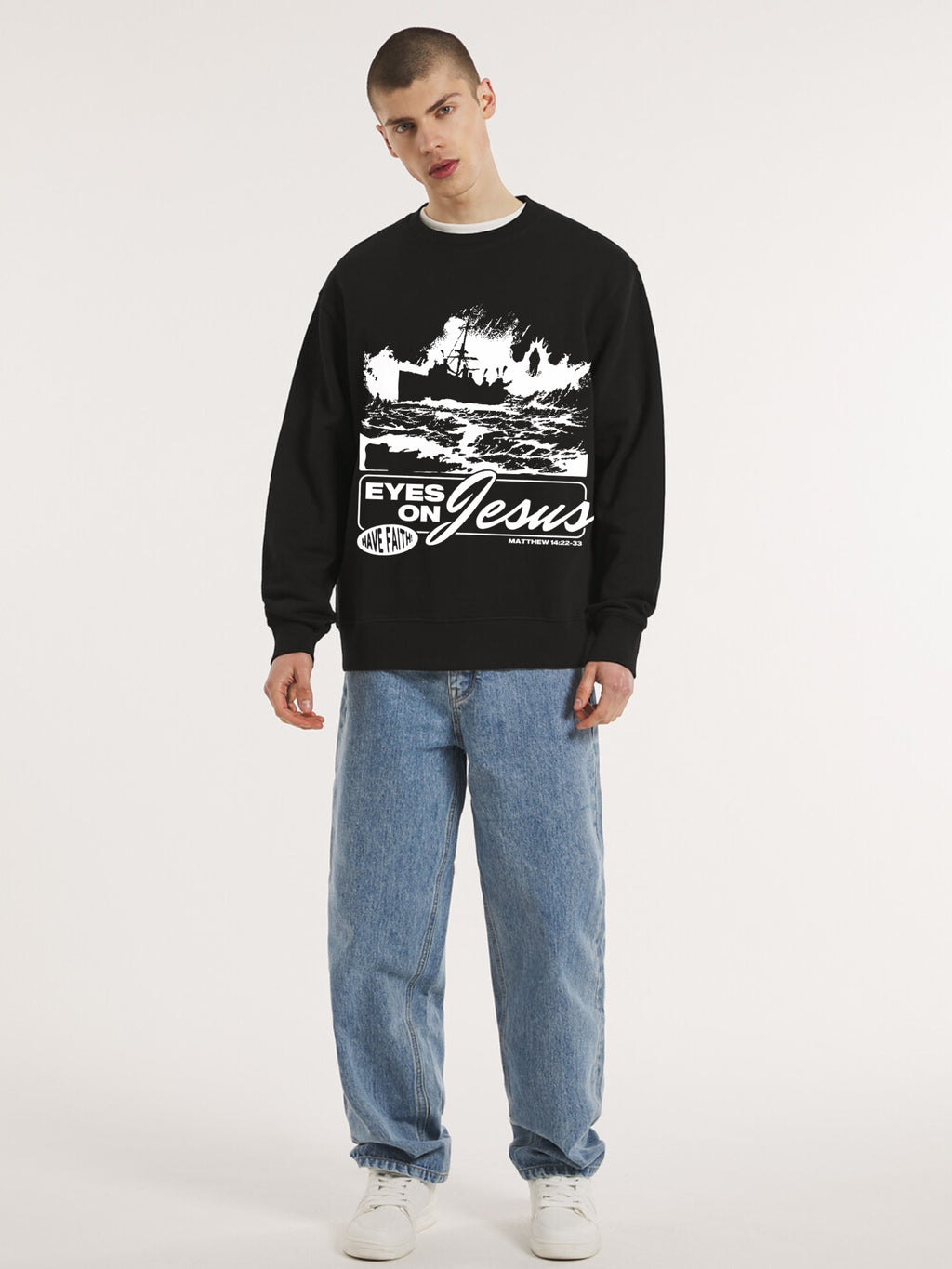 Man wearing the SĒK Apparel Eyes on Jesus Crewneck in black — front view of faith-inspired Christian sweatshirt with 'Eyes on Jesus' text and Jesus on the water