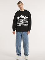 Man wearing the SĒK Apparel Eyes on Jesus Crewneck in black — front view of faith-inspired Christian sweatshirt with 'Eyes on Jesus' text and Jesus on the water