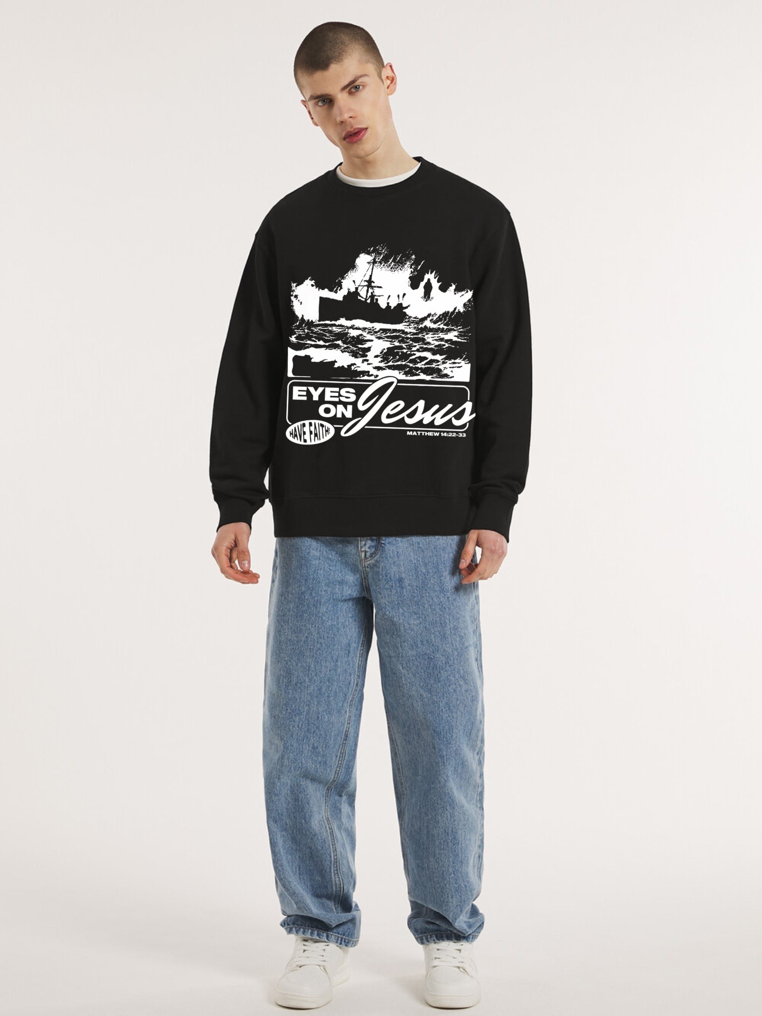 Man wearing the SĒK Apparel Eyes on Jesus Crewneck in black — front view of faith-inspired Christian sweatshirt with 'Eyes on Jesus' text and Jesus on the water