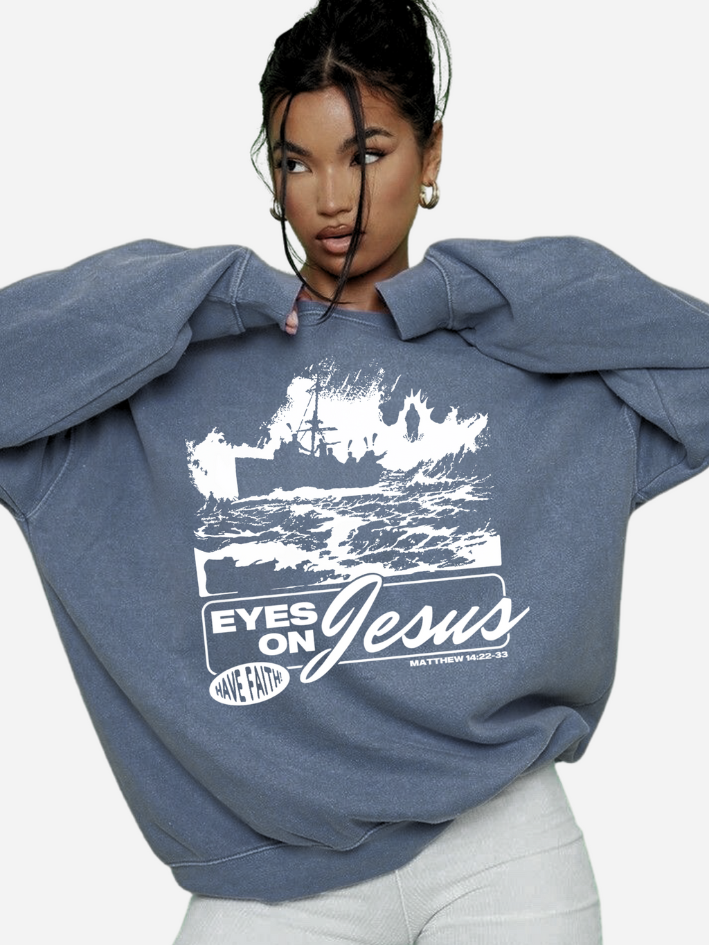 Woman wearing the SĒK Apparel Eyes on Jesus Crewneck in blue — faith-inspired Christian crewneck sweatshirt with 'Eyes on Jesus' text and Jesus on the water