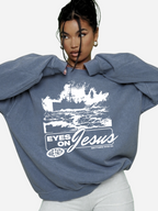 Woman wearing the SĒK Apparel Eyes on Jesus Crewneck in blue — faith-inspired Christian crewneck sweatshirt with 'Eyes on Jesus' text and Jesus on the water