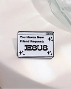 A pin with the text 'You Havea New Friend Request: JESUS' on a white surface.