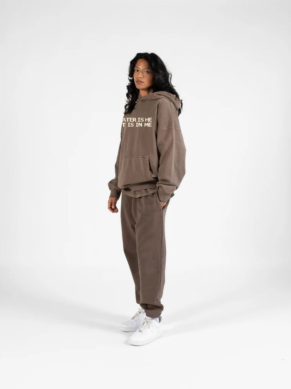Woman wearing SĒK Apparel Greater is He Hoodie in brown — front view