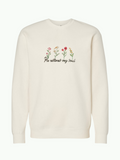 SĒK Apparel He Restores Crewneck in beige — flat lay of faith-inspired Christian sweatshirt with embroidered 'He Restores' text and floral detail, referencing Psalm 23:3
