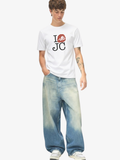 Man wearing the SĒK Apparel I Love JC Character Tee in white — faith-inspired Christian graphic tee with 'I Love JC' character design, styled with blue jeans on white background
