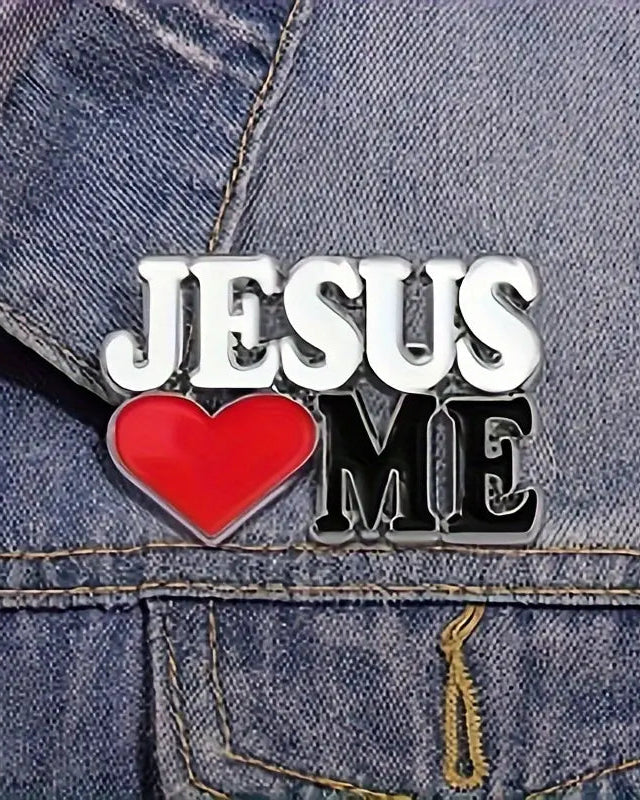 SĒK Apparel Jesus Loves Me enamel pin shown on a denim jacket — stylized 'Jesus Loves Me' text with silver detailing, faith-inspired Christian lapel pin