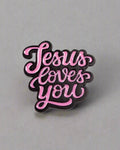 SĒK Apparel Jesus Loves You enamel pin — pink pin with 'JESUS LOVES YOU' in cursive letters, faith-inspired Christian lapel pin