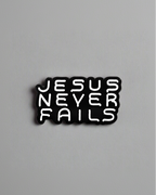 SĒK Apparel Jesus Never Fails enamel pin — black pin with 'JESUS NEVER FAILS' in bold white letters, faith-inspired Christian lapel pin