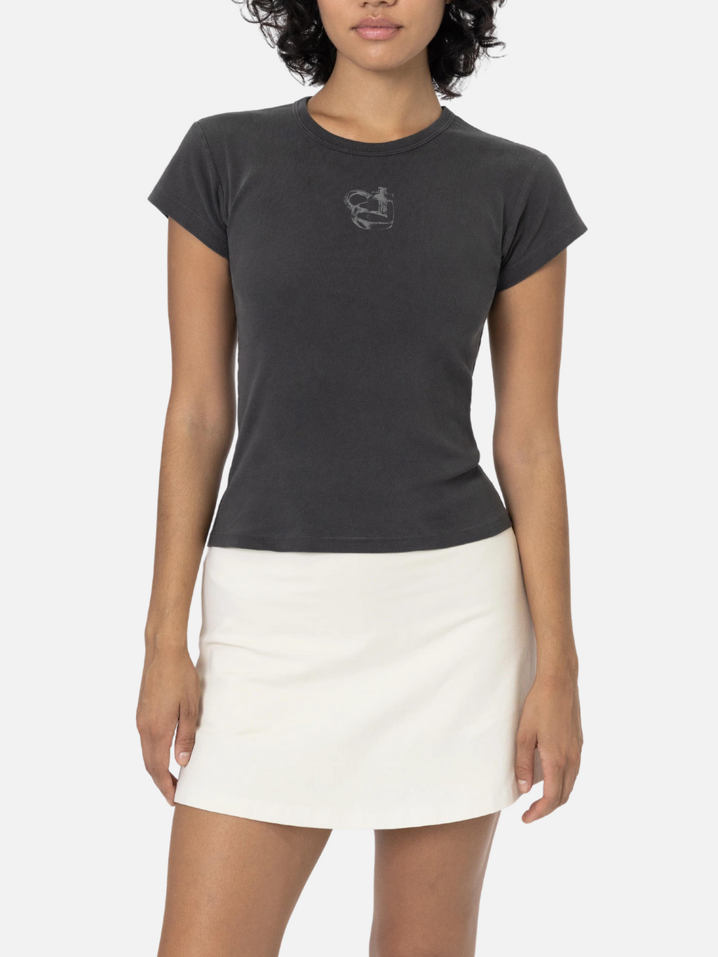 Woman wearing the SĒK Apparel Jesus is the Key Baby Tee in gray — front view of faith-inspired Christian tee with heart lock and cross key design, styled with a white skirt