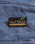 SĒK Apparel Last Supper enamel pin —shown pinned to denim fabric
