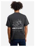 Man wearing the SĒK Apparel Made to Glorify Tee in faded black — back view with bold 'Made to Glorify' text, faith-inspired Christian graphic tee