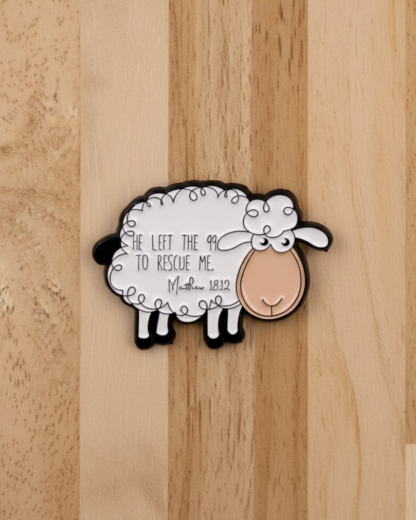 SĒK Apparel Matthew 18:12 enamel pin — white sheep design with 'He Left the 99 to Rescue Me — Matthew 18:12' script text, faith-inspired Christian lapel pin referencing the parable of the lost sheep