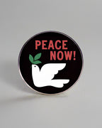 SĒK Apparel Peace Now enamel pin — black pin with white dove and bold 'Peace Now!' text in red, faith-inspired Christian lapel pin referencing John 14:27