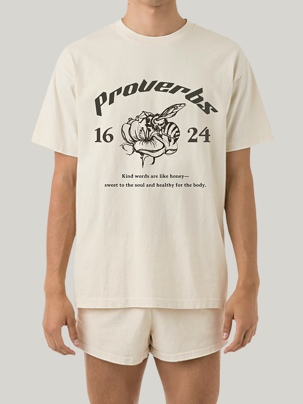 Man wearing the SĒK Apparel Proverbs 16:24 Graphic Tee — front view of faith-inspired Christian graphic tee with honey illustration and 'Gracious Words Are a Honeycomb' design, referencing Proverbs 16:24