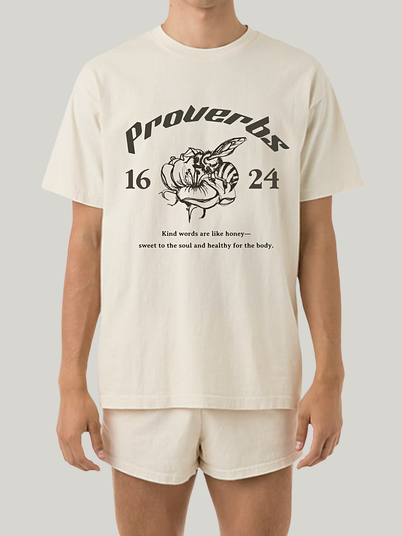 Man wearing the SĒK Apparel Proverbs 16:24 Graphic Tee — front view of faith-inspired Christian graphic tee with honey illustration and 'Gracious Words Are a Honeycomb' design, referencing Proverbs 16:24