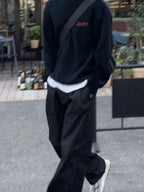 Man wearing the SĒK Apparel Steadfast Crewneck in navy — front view of faith-inspired Christian sweatshirt with embroidered 'Steadfast' design, styled with black pants and white sneakers