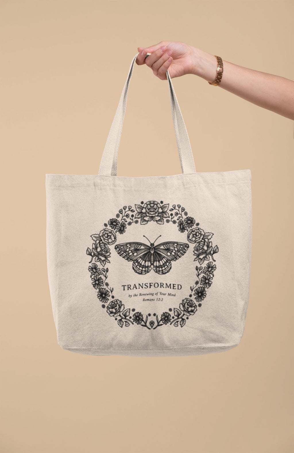 SĒK Apparel Transformed Butterfly Tote — product shot of faith-inspired Christian canvas tote bag with butterfly design and 'Transformed' text, referencing Romans 12:2