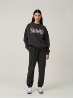Woman wearing the SĒK Apparel YAHWEH Crewneck in gray — front view of faith-inspired Christian sweatshirt with bold 'YAHWEH' text, styled with black pants